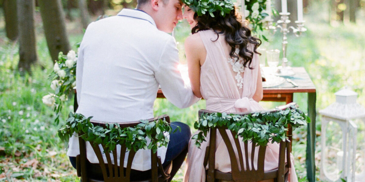 Couple amoureux assis sur des chaises en bois dans un beau jardin