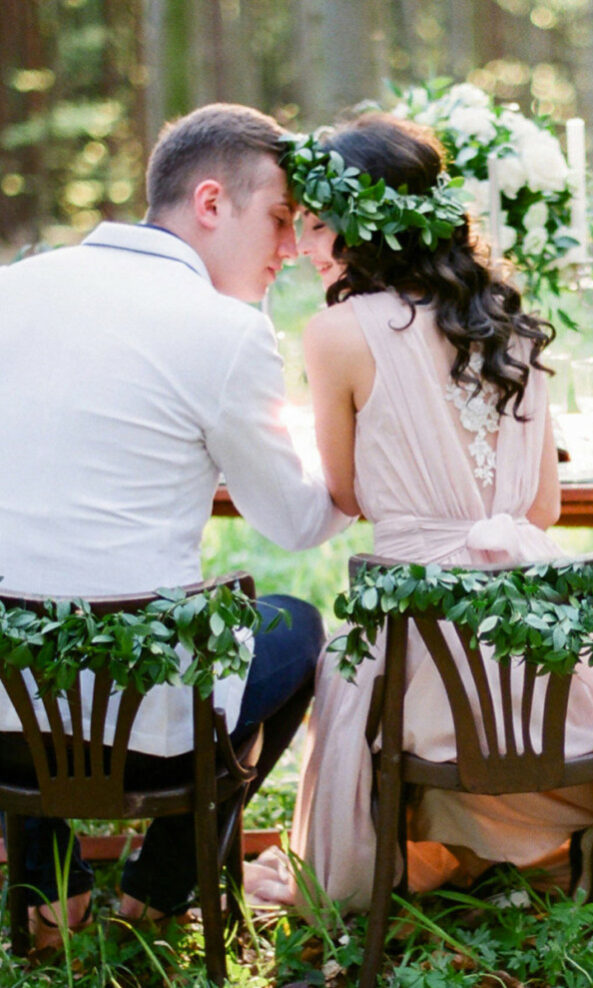 Couple amoureux assis sur des chaises en bois dans un beau jardin