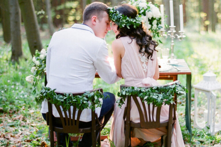Couple amoureux assis sur des chaises en bois dans un beau jardin